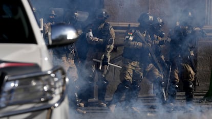 Agentes de la Policía Militar entre gases lacrimógenos que dispararon frente al palacio presidencial en la Plaza Murillo en La Paz.