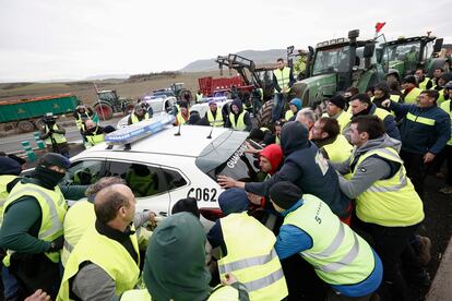 Un grupo de agricultores mueven un coche de la Guardia Civil para acceder a Pamplona, el 8 de febrero.
