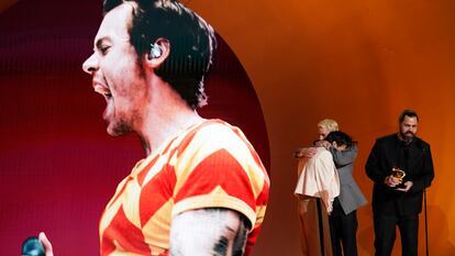 Harry Styles, left, embraces Kid Harpoon, center, while Tyler Johnson accepts the award for album of the year for 'Harry's House' at the 65th annual Grammy Awards on Sunday, Feb. 5, 2023, in Los Angeles.
