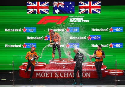 En lo más alto del podio, Oscar Piastri, de Mc Laren, junto a su compañero de equipo, Lando Norris, a la izquierda. A la derecha, George Russell, de Mercedes, y Charlie Hooper, ingeniero de McLaren.